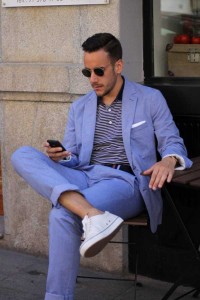 A model in a summer suit scrolling on his phone..